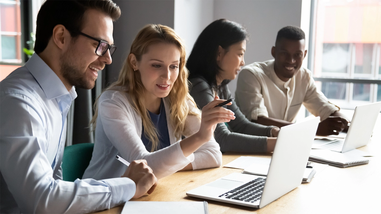 group of people in office looking at laptop
