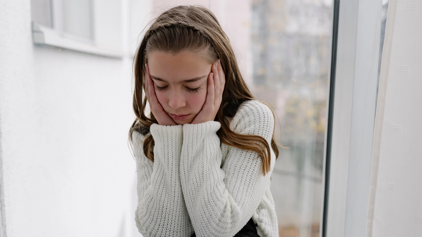 upset young girl with head in hands