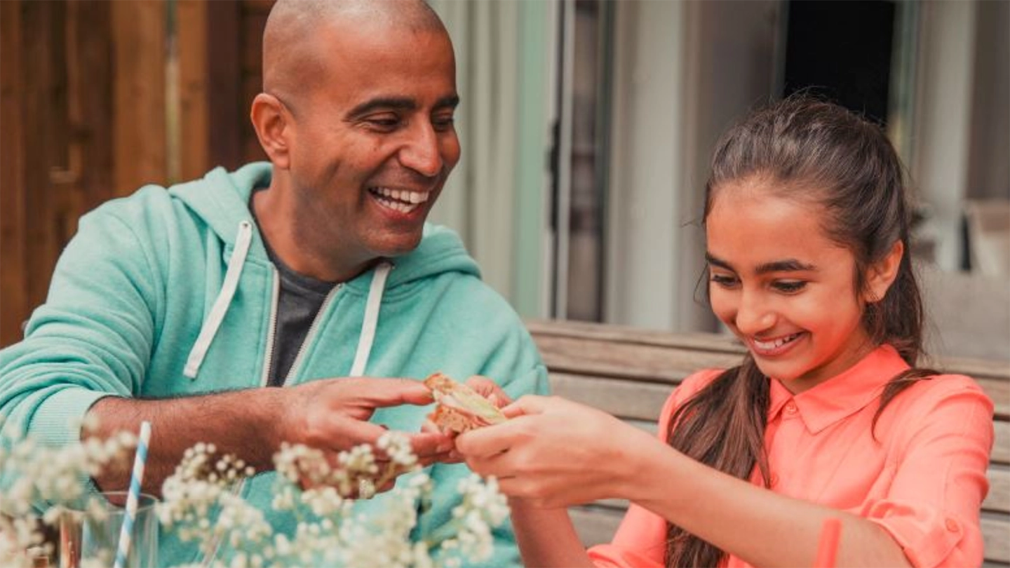man helping happy child plant flowers in the garden