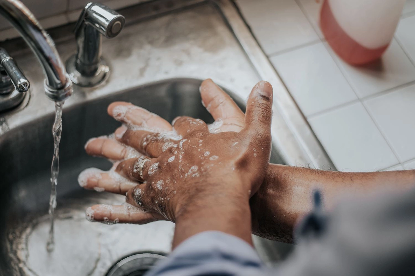 man washing hands in the sink