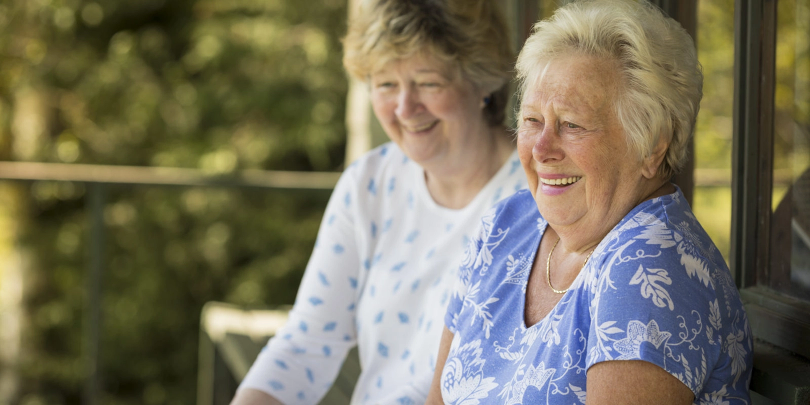 two senior women laughing outdoors